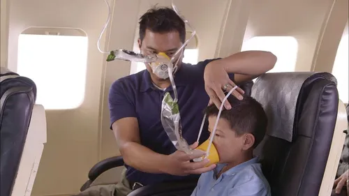 father placing oxygen mask on son