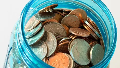 A glass jar full of coins.