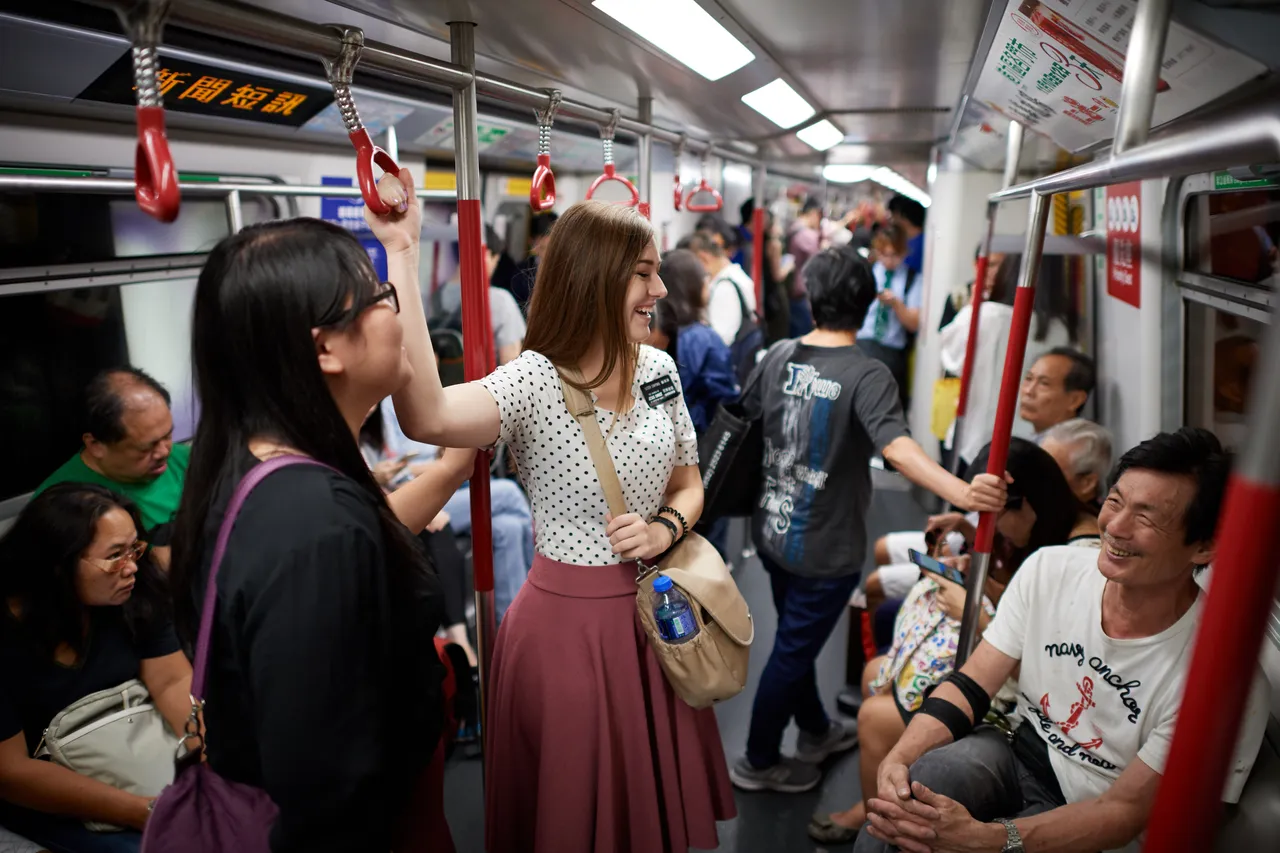 Two sister missionaries speak with a man while riding a bus