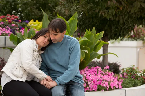 couple comforting one another on temple grounds