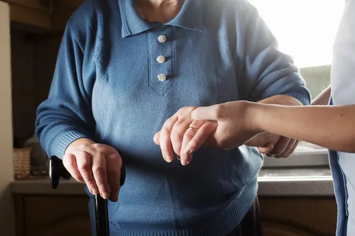 care assistant helping senior woman to walk