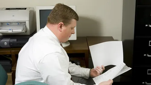 người đàn ông đang nhìn vào tờ giấy