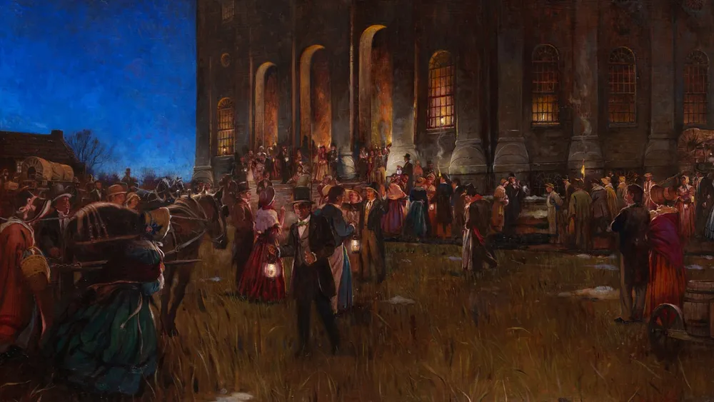 People coming and going in front of a building at nighttime.