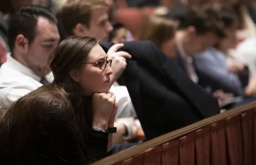 Woman leaning forward listening to general conference.