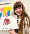 Girl holding up a picture she drew