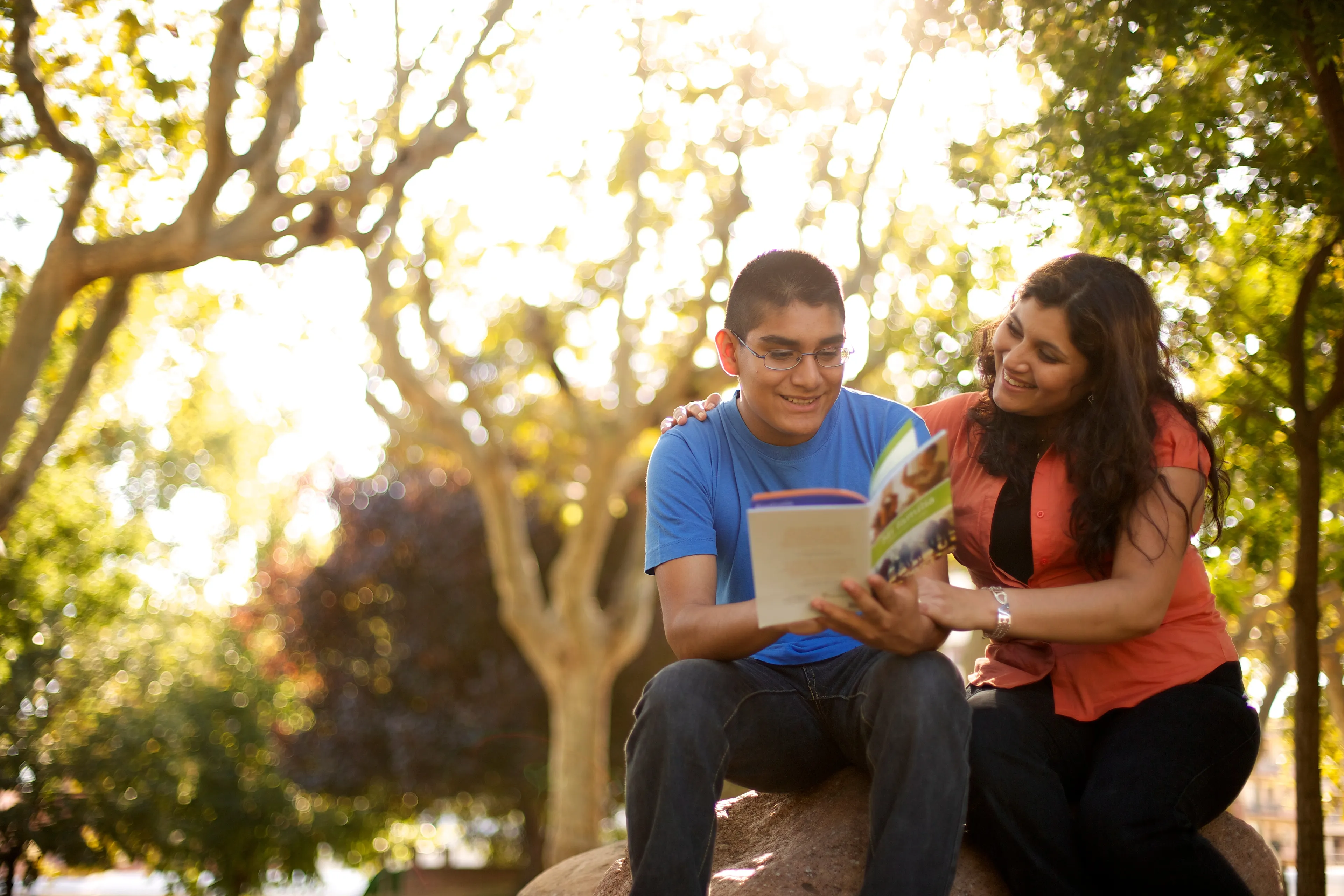 A mother looking through a family history pamphlet with her son.  