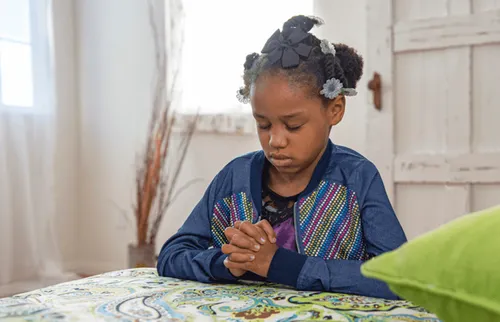 Photo of girl kneeling in prayer