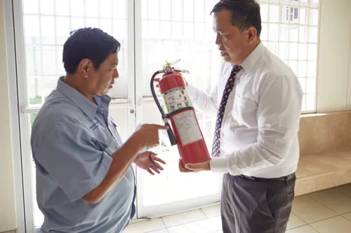 two men inspecting a fire extinguisher