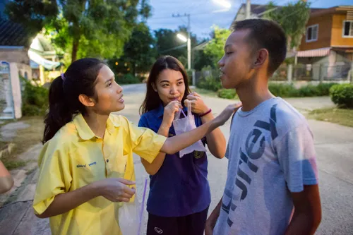 three youth interacting outside