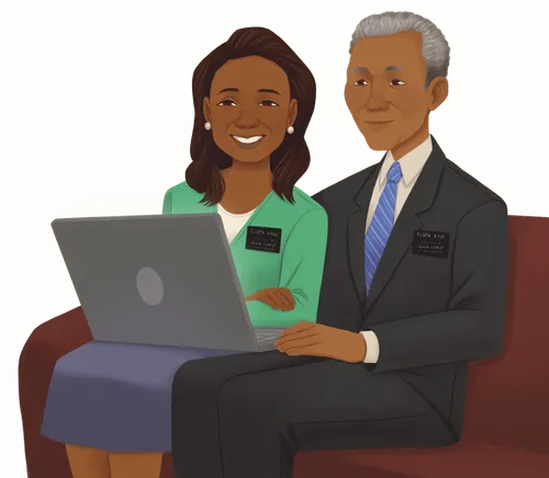 Husband and wife wearing nametags looking at laptop