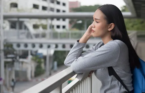 Young Filipino woman leaning against railing