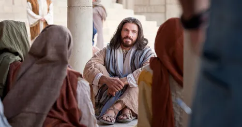 Christ sitting on the ground teaching a group of people