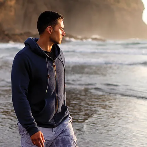 young man walking along the water