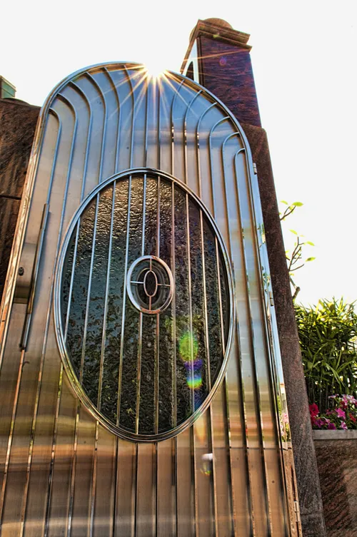 The metal and glass door on the gate leading to the Hong Kong China Temple, reflecting a ray of sunlight.