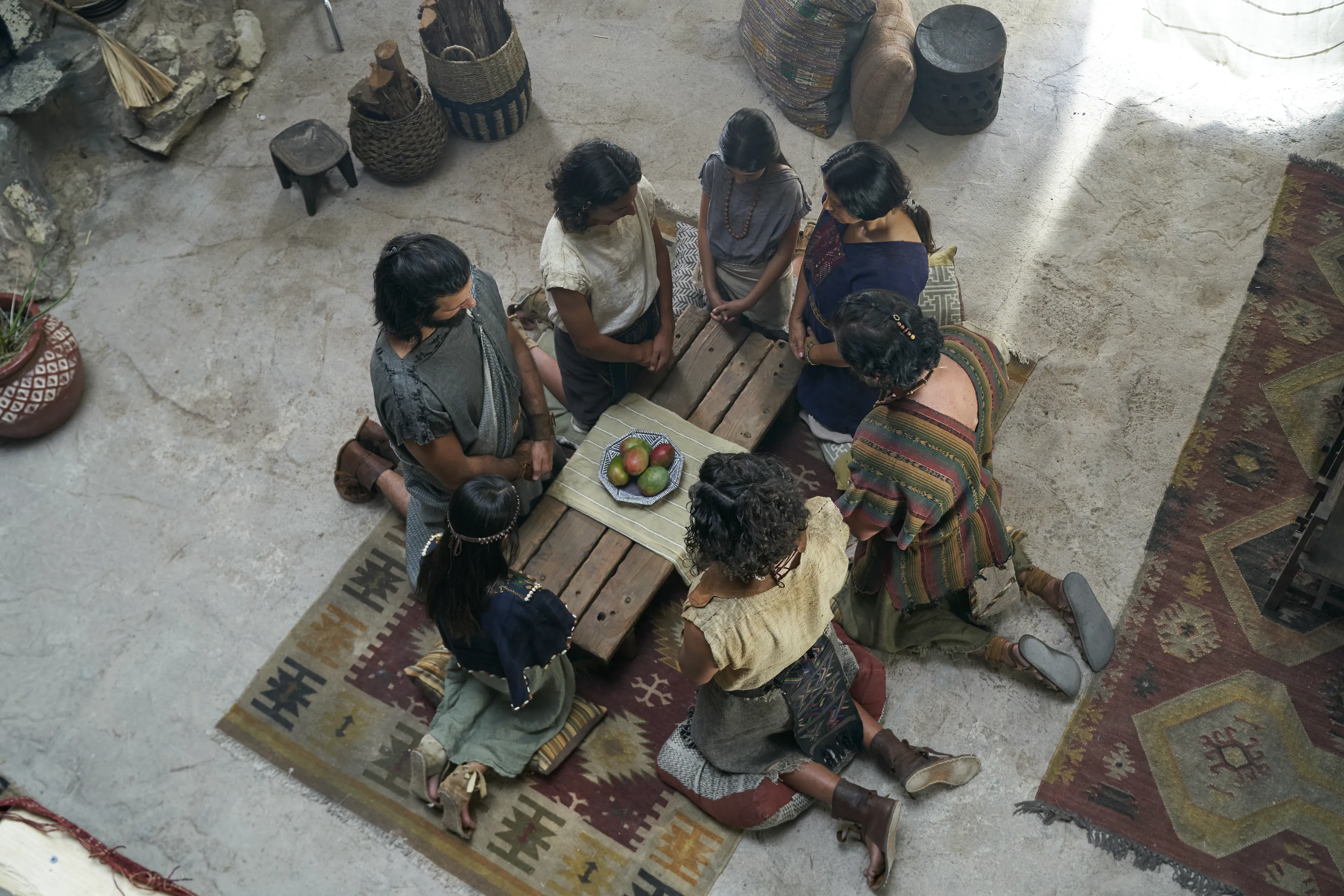 Alma the Younger and Amulek and his family kneel and pray together in the house of Amulek in the city of Ammonihah.
