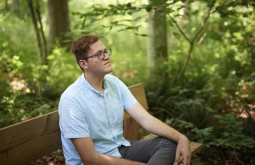 Young adult sitting in the Sacred Grove