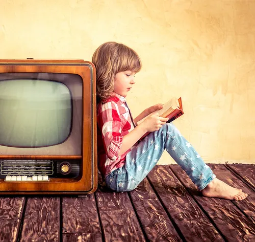 child leaning on old tv