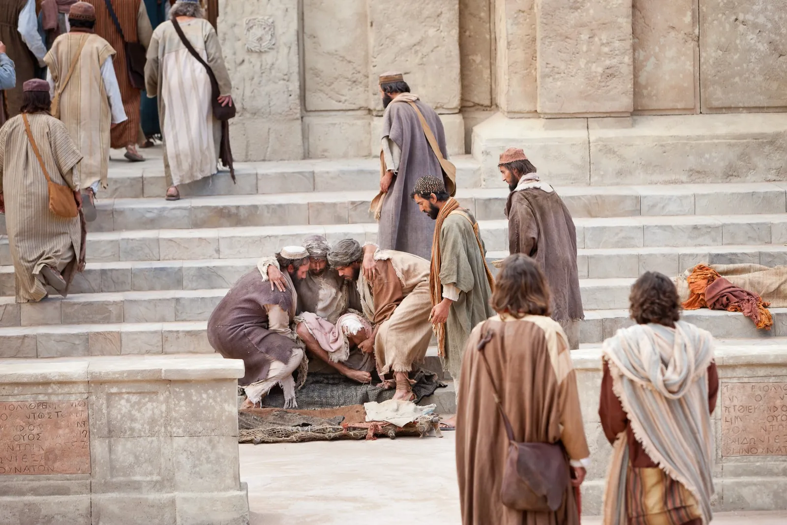 Men carry a cripple since birth and set him on the steps.