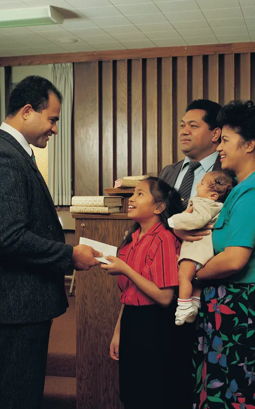 A photograph by Steve Bunderson depicting a young girl at church standing next to her parents and handing a tithing envelope to her bishop.