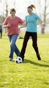 older woman and young woman playing soccer