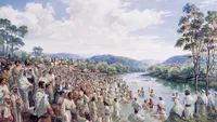 A large crowd of people being baptized in a river at the day of Pentecost.