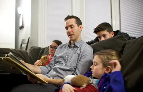 A father reads a book to his children