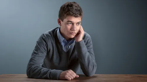 一个男子坐在桌前，看起来若有所思