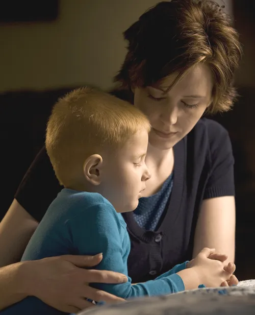 Mother praying with her young son