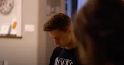 A teenager praying with his family