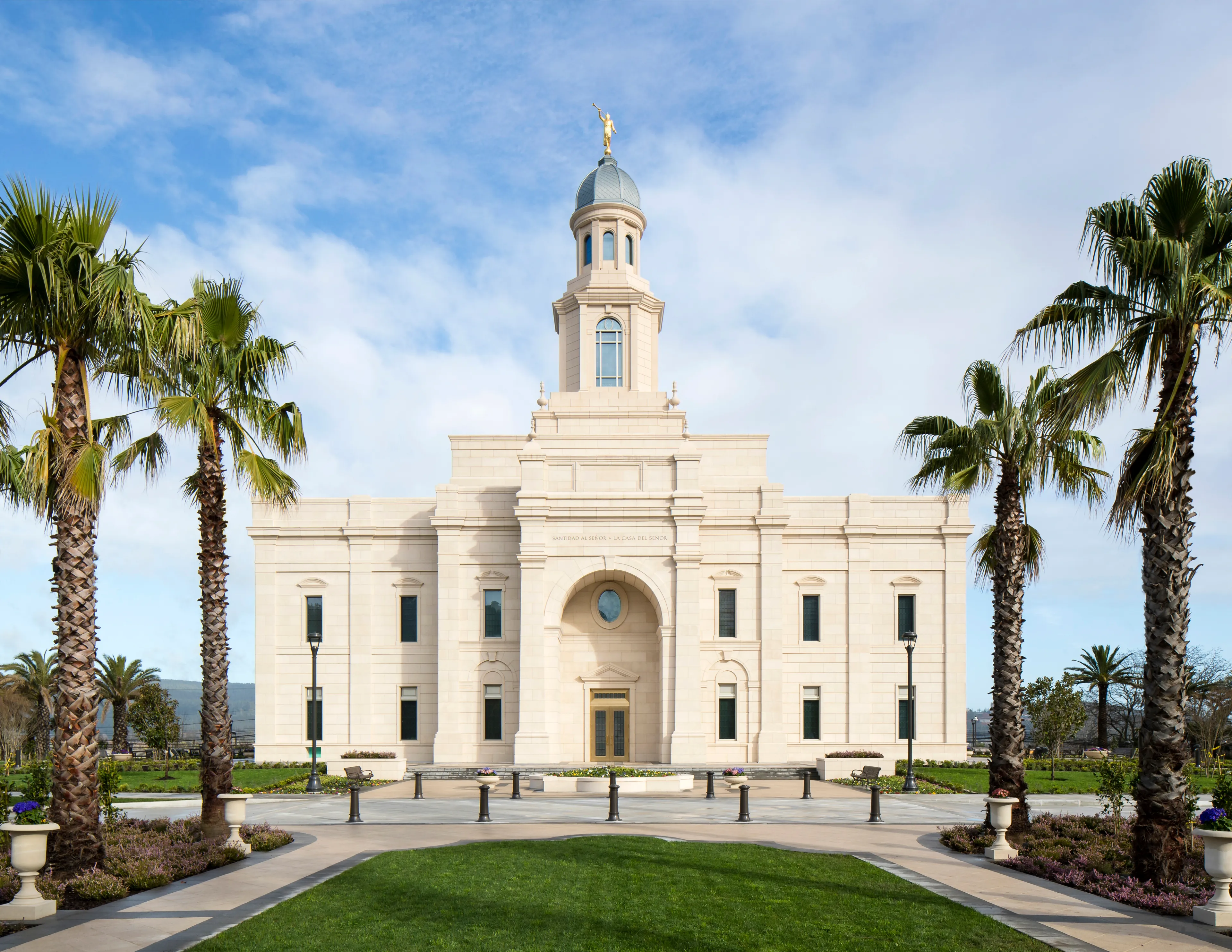 A front view of the Concepción Chile Temple entrance and palm tree–lined walkway.