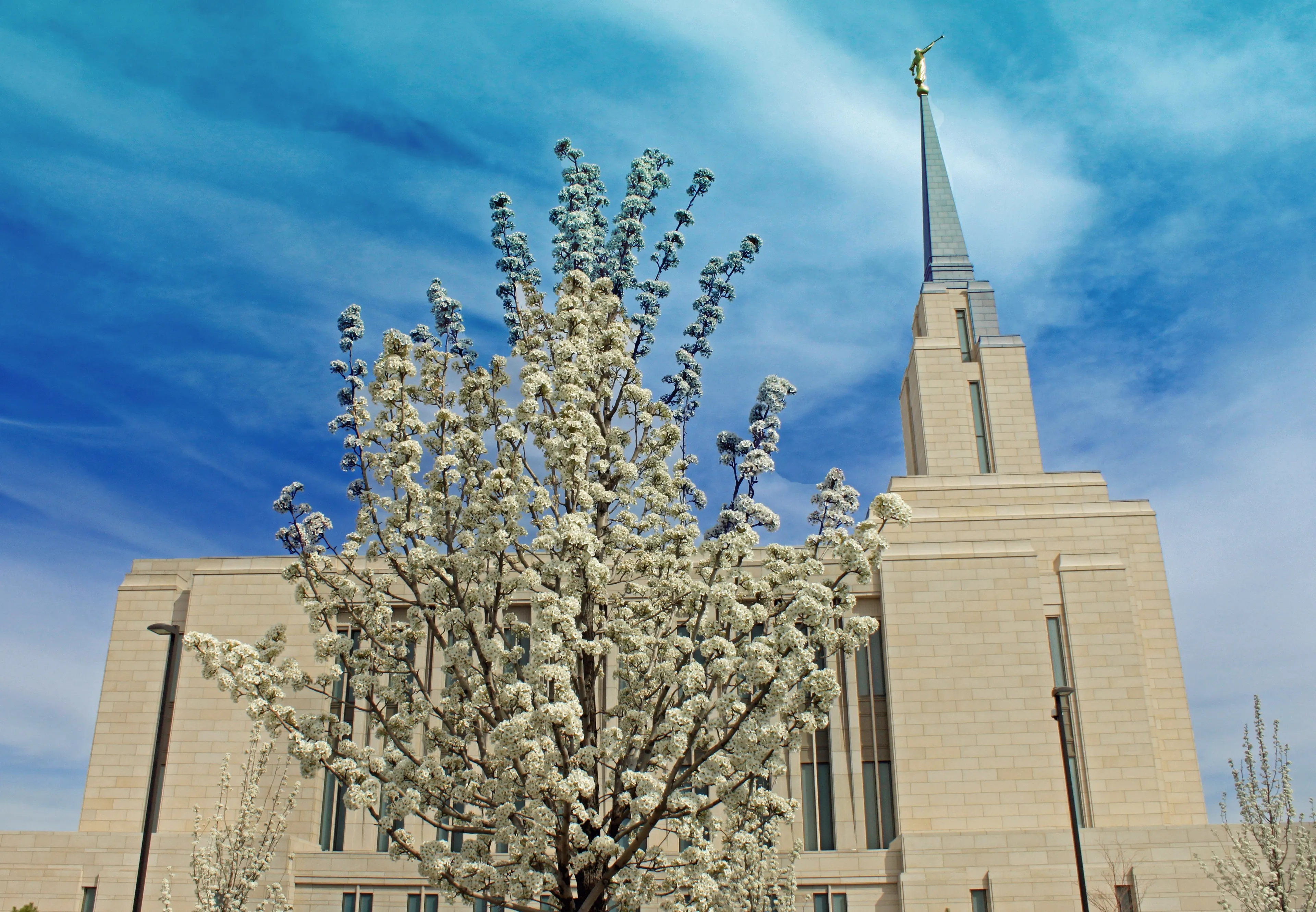 The Oquirrh Mountain Utah Temple side view, including the exterior of the temple, the spire, and scenery.