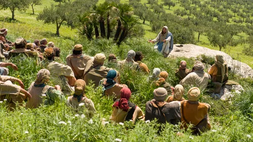 Jesus teaching people on a hillside
