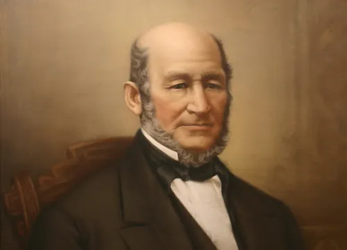 Seated portrait-half figure; lots of empty space above head; balding-grey short beard.