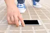 hand getting phone from floor