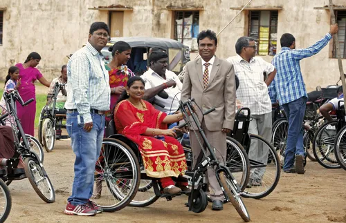 woman in India trying out hand-powered tricycle