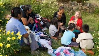 Sister missionaries teaching family outside in Bolivia