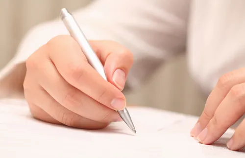 a figure in white holding a pen