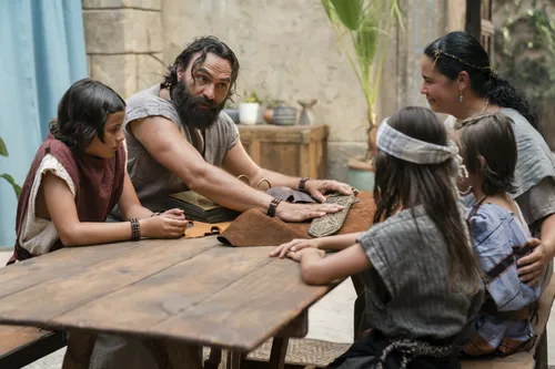King Benjamin gathers with his family around a table in the Land of Zarahemla and tells them he can no longer be king. He shows his family the brass plates.