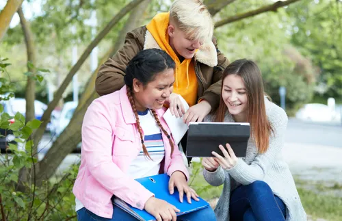 Teenagers gathered around a device