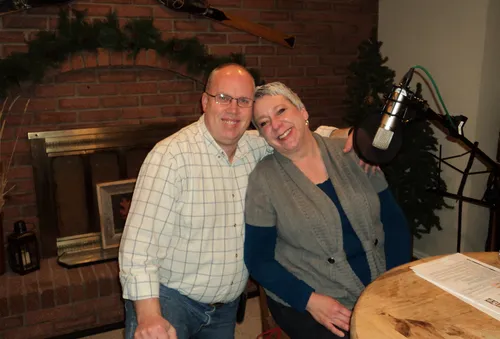 Jenny Wiscomb and a man beside a radio microphone.