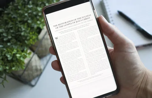 Hand holding phone with the proclamation on the Restoration 