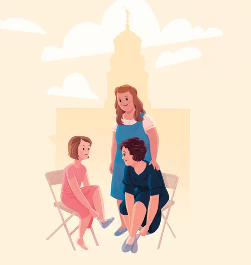 Two women and a girl putting on shoe coverings outside the temple