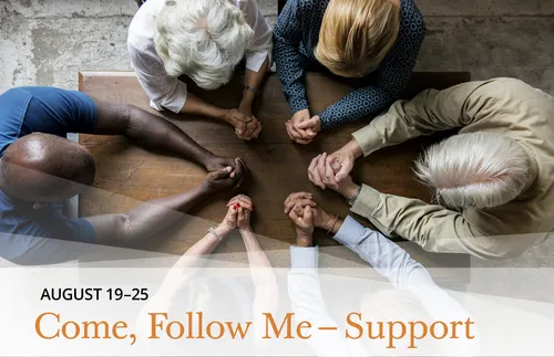 couples of different ethnicities gathered together praying at a table