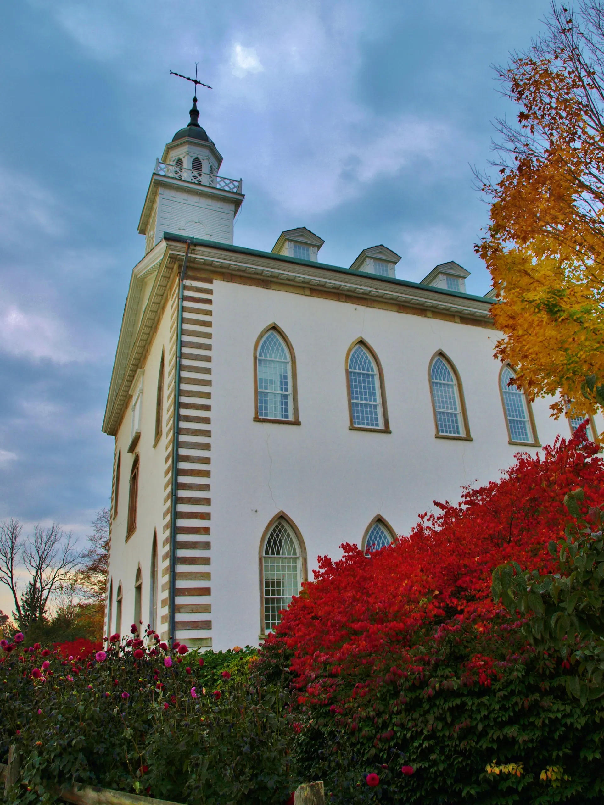 A side view of the Kirtland Temple in the fall, including scenery.