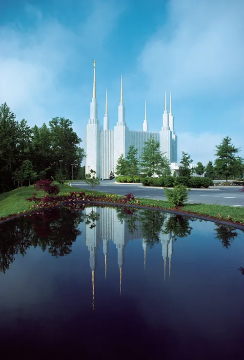 The Washington D.C. Temple during the day, with the reflecting pond in the foreground.