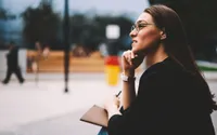 A woman sits on a park bench and ponders the role of God in her life