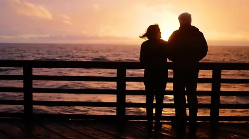 couple watching sun set over ocean