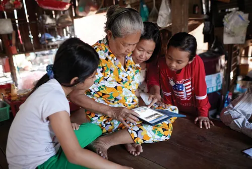 grandmother and grandchildren study with tablet