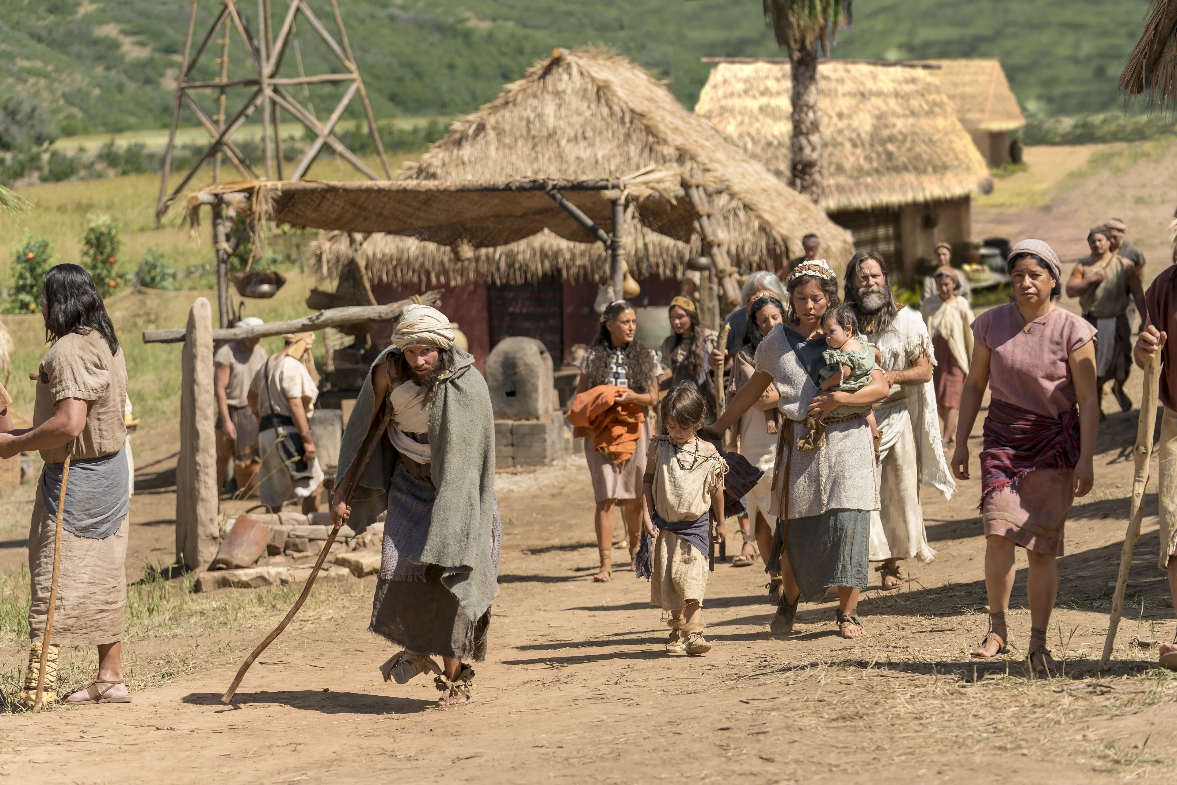 A disabled man walks in city streets with other Nephites.