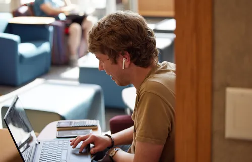 a man typing on a computer and smiling